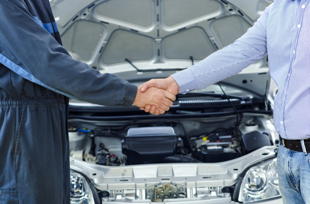 Car service mechanic and customer shaking hands excellent cooperation between car mechanic